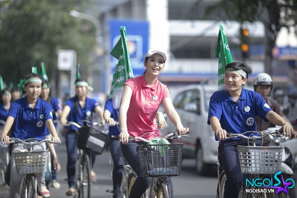 Hoa hậu Ngọc Hân diện áo hồng đạp xe dưới phố đông