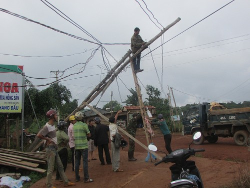 Người dân tại thôn 3 xã Quảng Khê (Đắk Glong, Đắk Nông)  tự dựng cột điện bằng gỗ