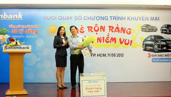 Bà Nguyễn Phương Huyền, Giám đốc Khách hàng cá nhân kiêm Trưởng phòng Dịch vụ Ngân hàng cao cấp Sacombank, trao hoa và quà cho khách hàng may mắn đến tham dự buổi quay số.