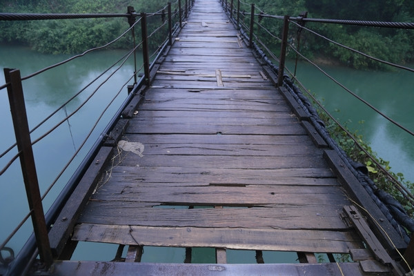 Hãi hùng cảnh người dân vượt sông trên cầu treo 