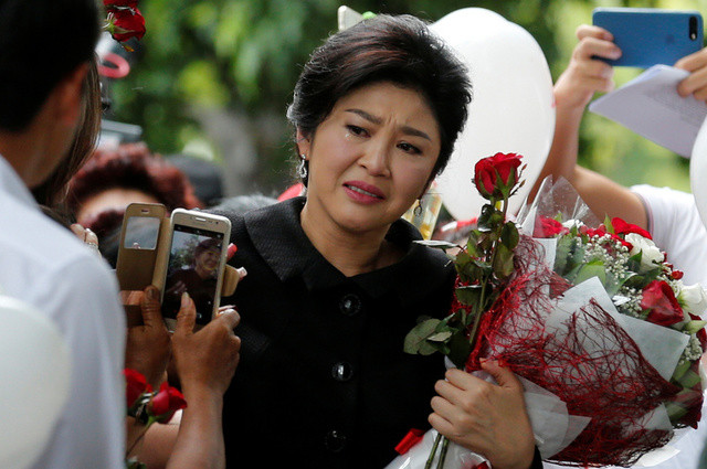 Cựu thủ tướng Thái Lan Yingluck Shinawatra khóc khi nhận hoa của những người ủng hộ ngoài tòa án hôm 21/7 (Ảnh: Reuters)