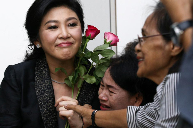 Cựu Thủ tướng Thái Lan Yingluck nhận hoa từ những người ủng hộ bên ngoài tòa án. (Ảnh: Reuters)