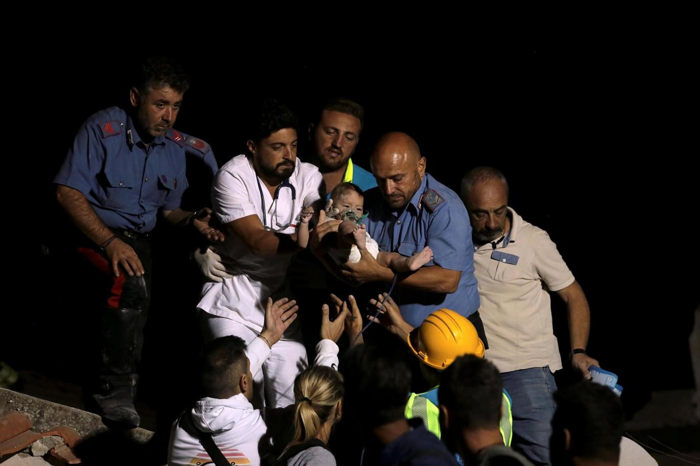 Em bé 7 tháng tuổi được đưa ra khỏi đống đổ nát - Ảnh: Reuters