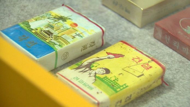 Hai vỏ bao thuốc lá tại Triều Tiên, trong đó vỏ bên trái có ghi chữ “Thiên đường”. Theo khảo sát năm 2012 của Tổ chức Y tế thế giới (WHO), hơn một nửa đàn ông Triều Tiên hút thuốc lá và đây là một trong những nước có tỷ lệ hút thuốc cao nhất ở châu Á. (Ảnh: BBC)