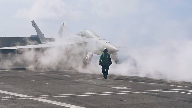 Trong chuyến thăm của đoàn phóng viên lên tàu USS Carl Vinson gần đây, Thiếu tá Mason Berry đã phát cho các phóng viên áo bảo hộ trước khi chỉ cho họ các ngóc ngách trên tàu sân bay lớp Nimitz. (Ảnh: CNA)