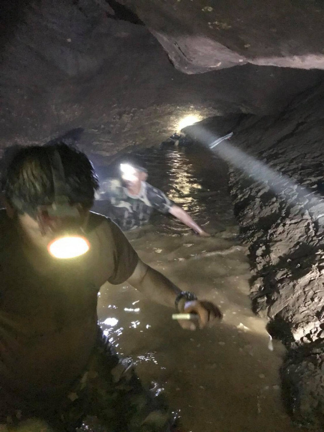 Lực lượng cứu hộ phải sử dụng đèn để di chuyển trong hang tối ngập nước (Ảnh: Bangkok Post)