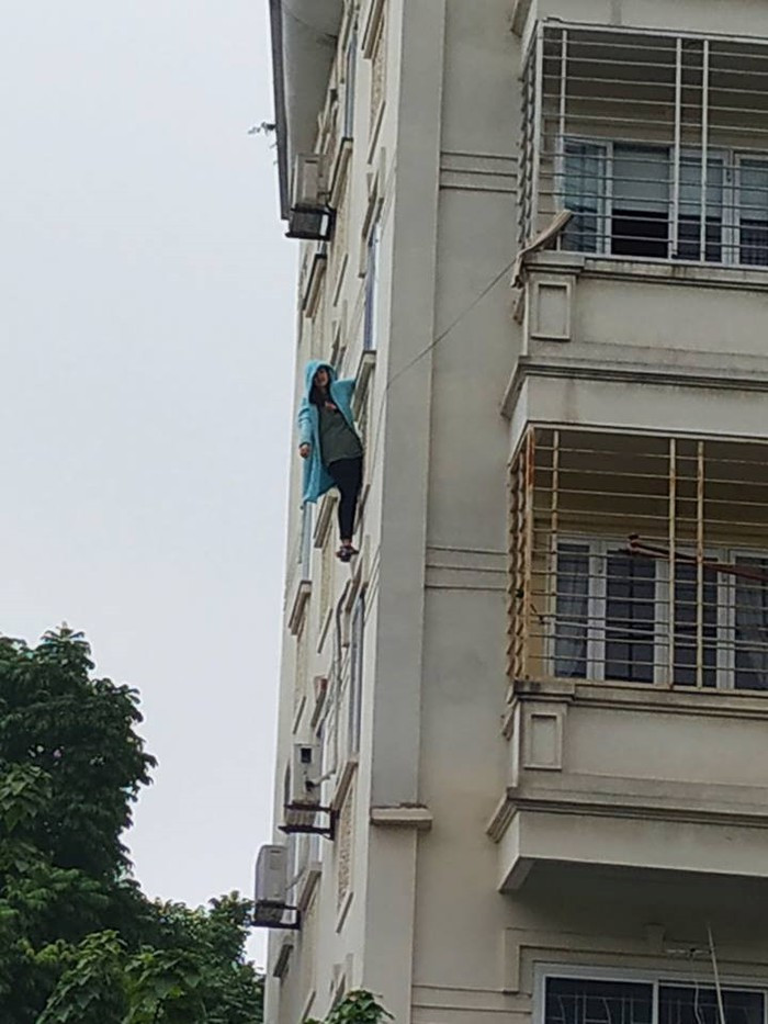 Giải cứu cô gái đu mình trên cửa sổ chung cư ở Hà Nội