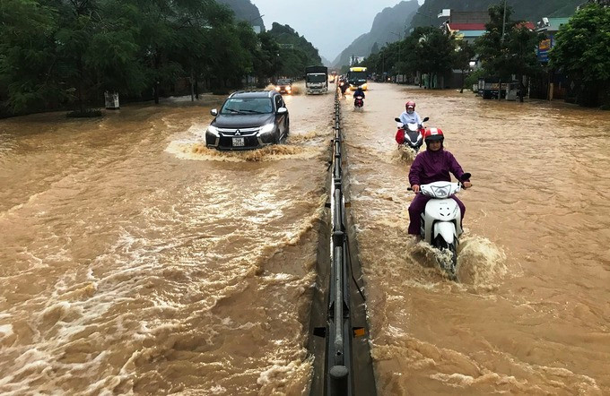 Cơn mưa lớn rạng sáng 17/8 khiến quốc lộ 18A đoạn qua phường Quang Hanh lụt kéo dài hơn 3 km. Ảnh: Minh Cương
