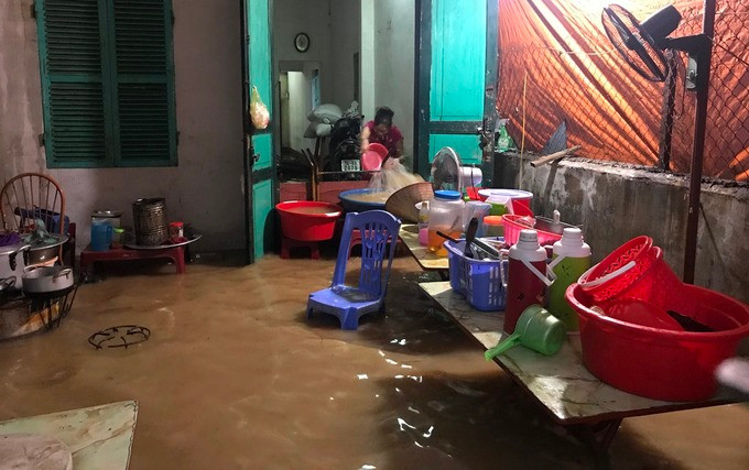 Người dân tát nước từ trong nhà ra. Ảnh: Minh Cương