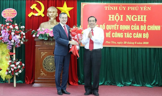 Đồng chí Phạm Đại Dương (bên trái) nhận quyết định và hoa chúc mừng.