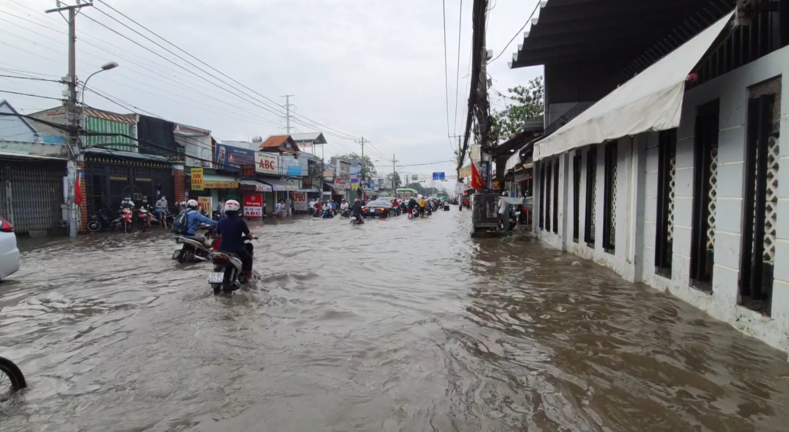 TPHCM: Triều cường dâng cao, người và phương tiện “lội” nước