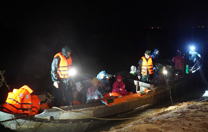 Trong mưa gió tối 27/10, lực lượng chức năng xã Tịnh An, TP Quảng Ngãi dùng thuyền đưa người dân ở thôn An Phú (một cồn nằm giữa sông Trà Khúc) vào bờ. Ảnh: Phước Tuấn.