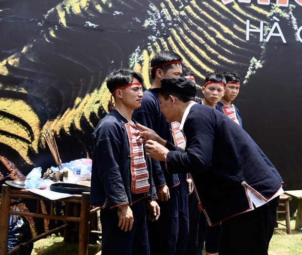 Thầy cúng ban vòng may mắn và trừ tà cho các chàng trai trước khi nhẩy lửa.
