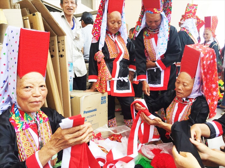 Bà con xuống chợ lựa chọn vải để may thêu trang phục.