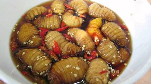 Đuông dừa tắm mắm là món ăn bao gồm những con đuông dừa còn sống, được ngâm trong bát mắm cay mằn mặn. (Ảnh: Internet)