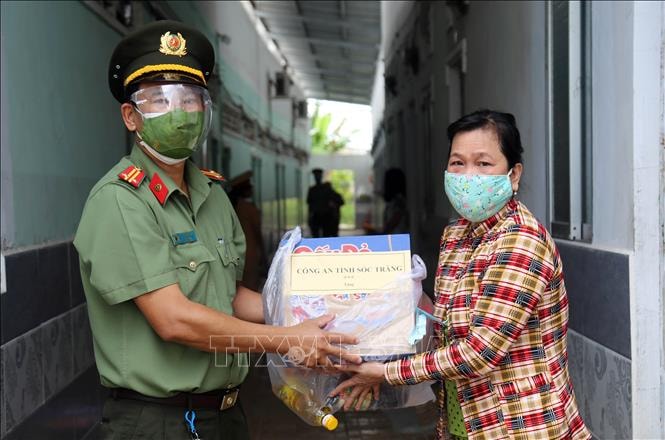 Cán bộ công an trao quà cho người lao động gặp khó khăn. 