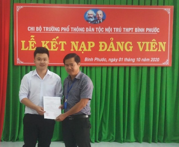 Thầy Phạm Thế Nam - Phó Bí thư Chi bộ, Phó hiệu trưởng Trường Phổ thông Dân tộc nội trú –THPT Bình Phước trao quyết định kết nạp Đảng cho học sinh ưu tú Trịnh Xuân Cảnh.