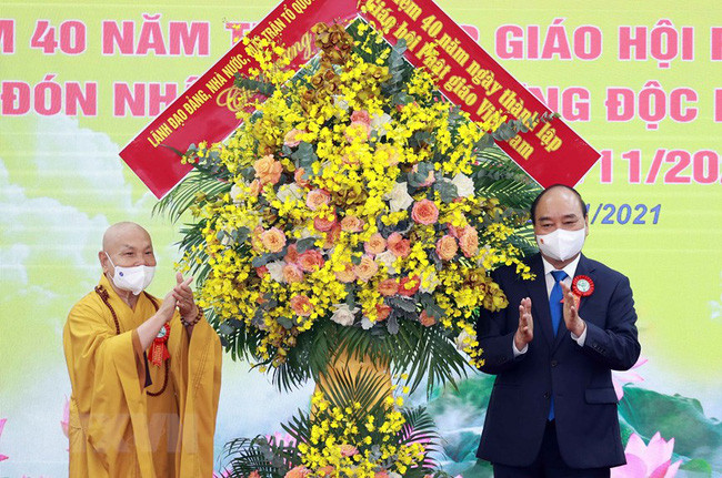 Chủ tịch nước Nguyễn Xuân Phúc tặng hoa chúc mừng Giáo hội Phật giáo Việt Nam. (Ảnh: TTXVN)