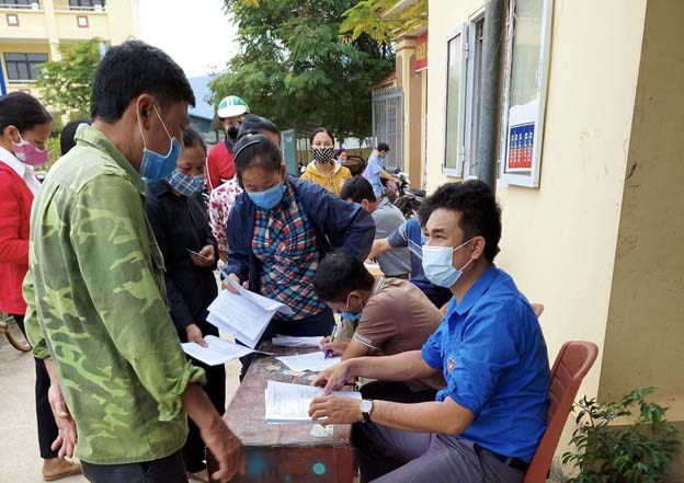 Giáo dân xã Tạ Xá, huyện Cẩm Khê hỗ trợ lực lượng y tế ghi thông tin của người dân đến tiêm phòng COVID-19