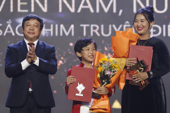 Diễn viên nhí Lại Trường Phú (giữa) nhận cúp vàng cho Nam chính điện ảnh xuất sắc cùng Nhã Uyên - giải Nữ chính điện ảnh xuất sắc.