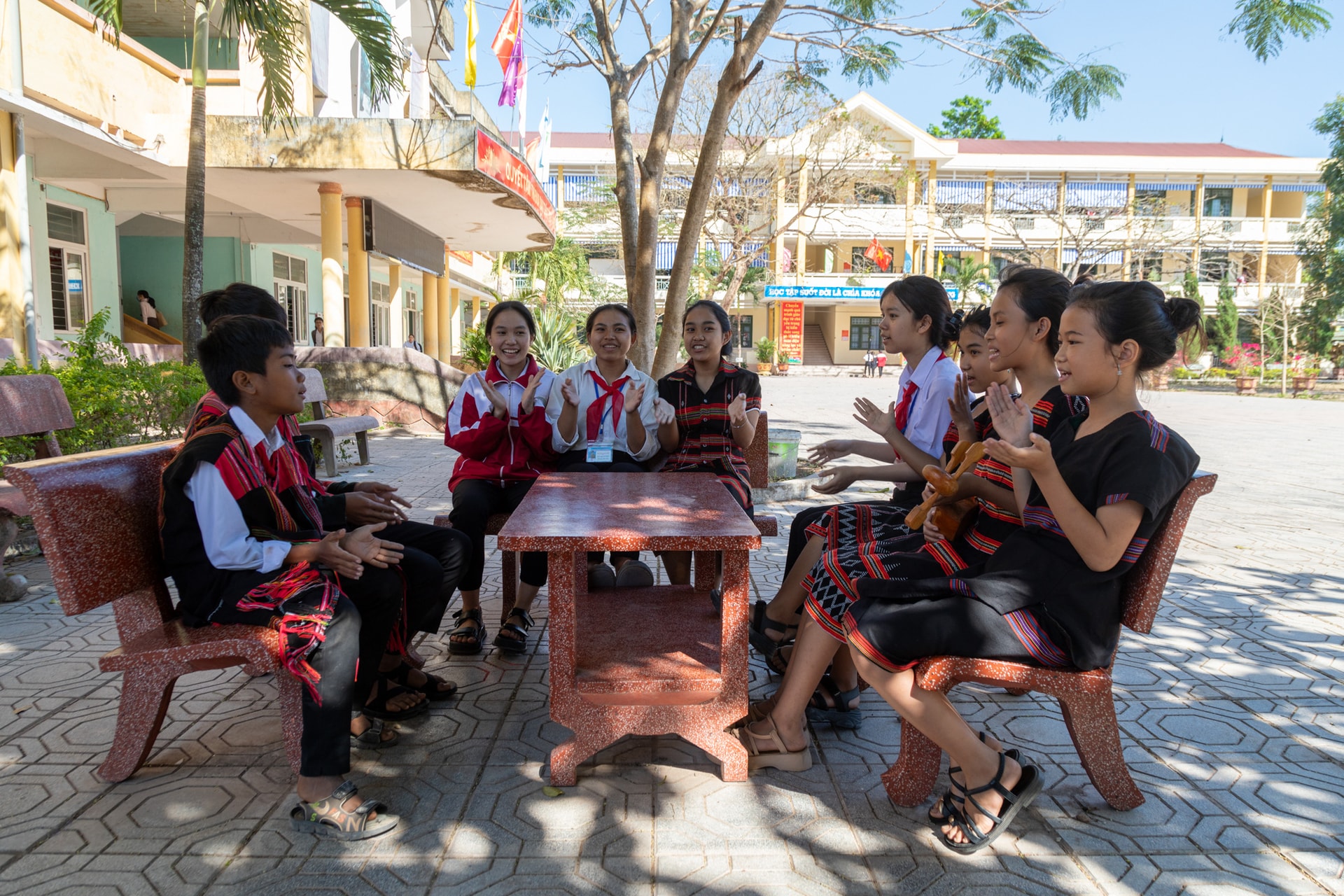 Thành viên câu lạc bộ dân ca Pa Kô tranh thủ tập hát ở ghế đá sân trường - Ảnh: HOÀNG TÁO