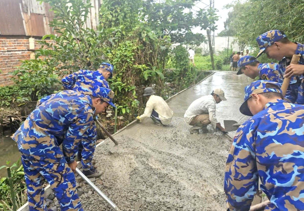hinh-2.-can-bo-dvtn-hai-don-vi-chung-tay-cung-ba-con-be-tong-hoa-tuyen-duong-giao-thong-nong-thon.jpg