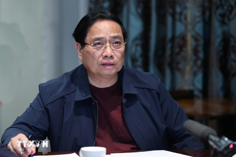 Thủ tướng Phạm Minh Chính họp trực tuyến từ Nam Phi chỉ đạo khắc phục hậu quả mưa lũ. (Ảnh: Dương Giang/TTXVN)