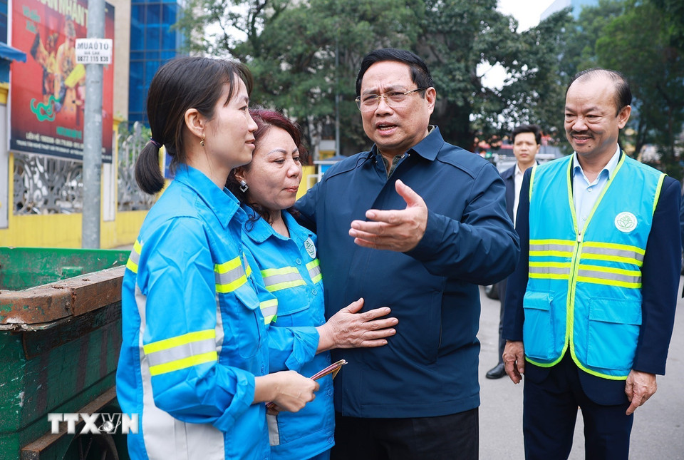 Thủ tướng Phạm Minh Chính thăm, chúc Tết công nhân đang thu gom, vận chuyển, xử lý rác thải khu vực đường Trần Nhân Tông-Hà Nội. (Ảnh: Dương Giang/TTXVN)