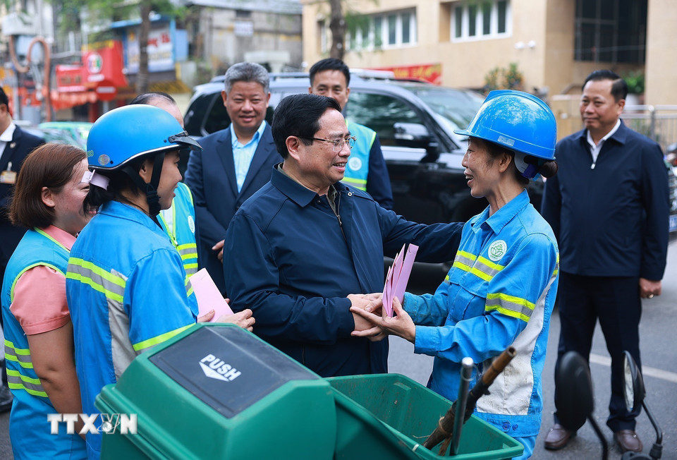 Thủ tướng Phạm Minh Chính thăm, chúc Tết công nhân đang thu gom, vận chuyển, xử lý rác thải khu vực Yên Thế-Nguyễn Thái Học. (Ảnh: Dương Giang/TTXVN)