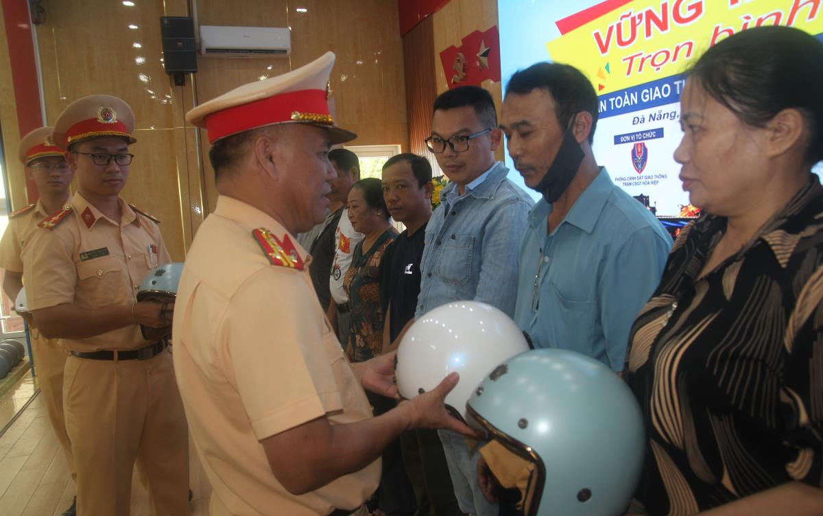 Đại tá Phan Thanh Hồng, Trưởng Phòng CSGT Công an TP Đà Nẵng trao tặng mũ bảo hiểm đạt chuẩn cho người dân tham gia chương trình