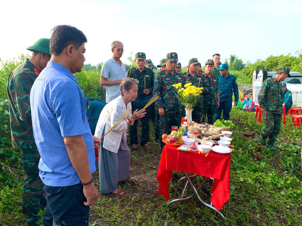 Bà Phạm Thị Gạo, em vợ của liệt sĩ Lâm Văn Sện, thắp hương tại khu vực tìm kiếm, quy tập hài cốt liệt sĩ.