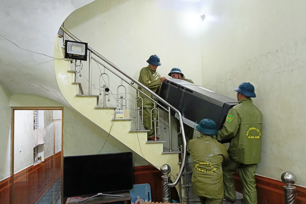 Ban CHQS xã Ba Chẽ giúp người dân di chuyển đồ đạc lên vị trí cao, an toàn khi nước sông Ba Chẽ dâng.