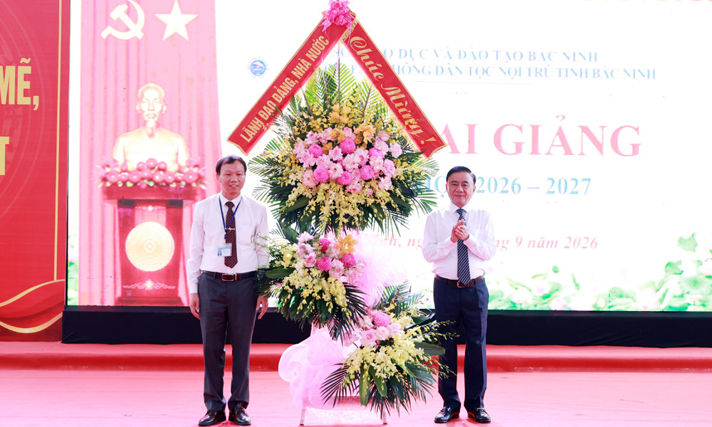 Thay mặt Đảng, Nhà nước, đồng chí Trần Cẩm Tú tặng hoa chúc mừng nhà trường. 
