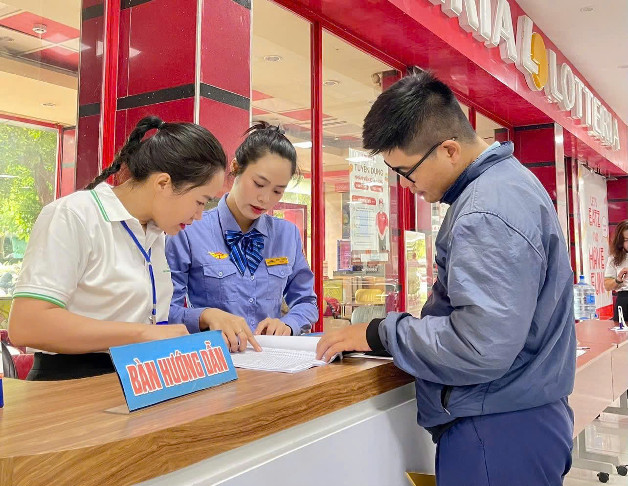 Nhân viên đường sắt hướng dẫn hành khách mua vé Tàu.