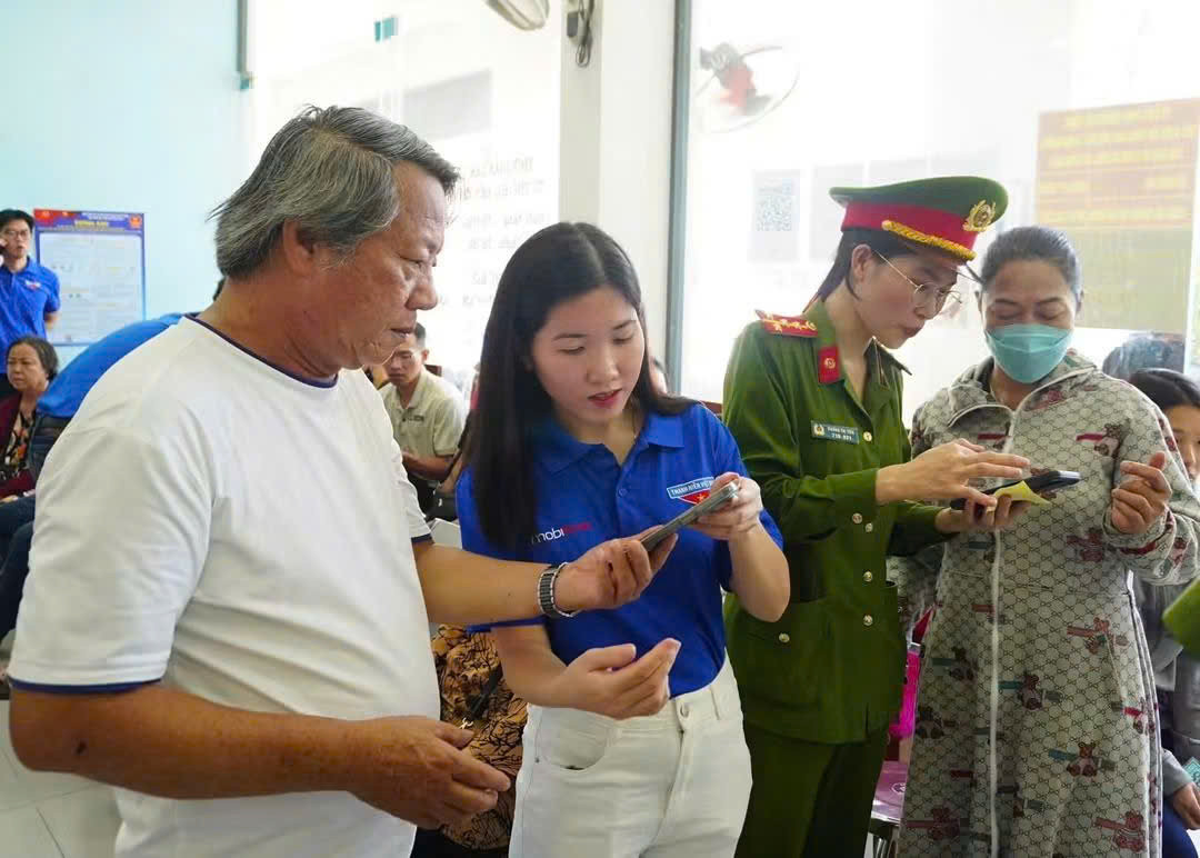 Người dân trải nghiệm các tiện ích số và được hướng dẫn sử dụng VNeID tại điểm hỗ trợ. (Ảnh: CA)