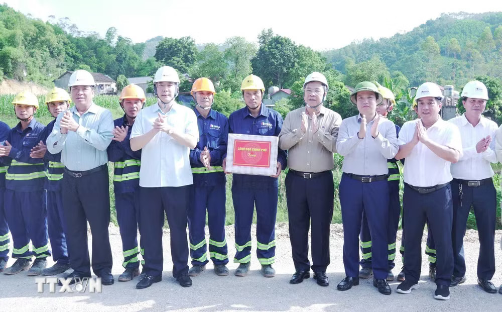 Phó Thủ tướng Thường trực Phạm Gia Túc cùng đại diện lãnh đạo Bộ Xây dựng và tỉnh Cao Bằng tặng quà động viên cán bộ, công nhân xây dựng tại công trường. (Ảnh: TTXVN phát) ttxvn_pho-thu-tuong-thuong-truc-kiem-tra-tien-do-thi-cong-cao-toc-dong-dang-tra-linh-9975.jpg