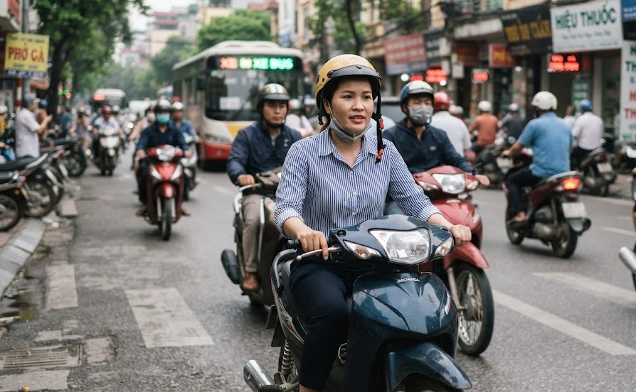 Không ít người điều khiển xe máy có thói quen đội mũ bảo hiểm nhưng không cài quai hoặc cài quai không đúng quy cách. (Ảnh minh hoạ tạo bằng AI).