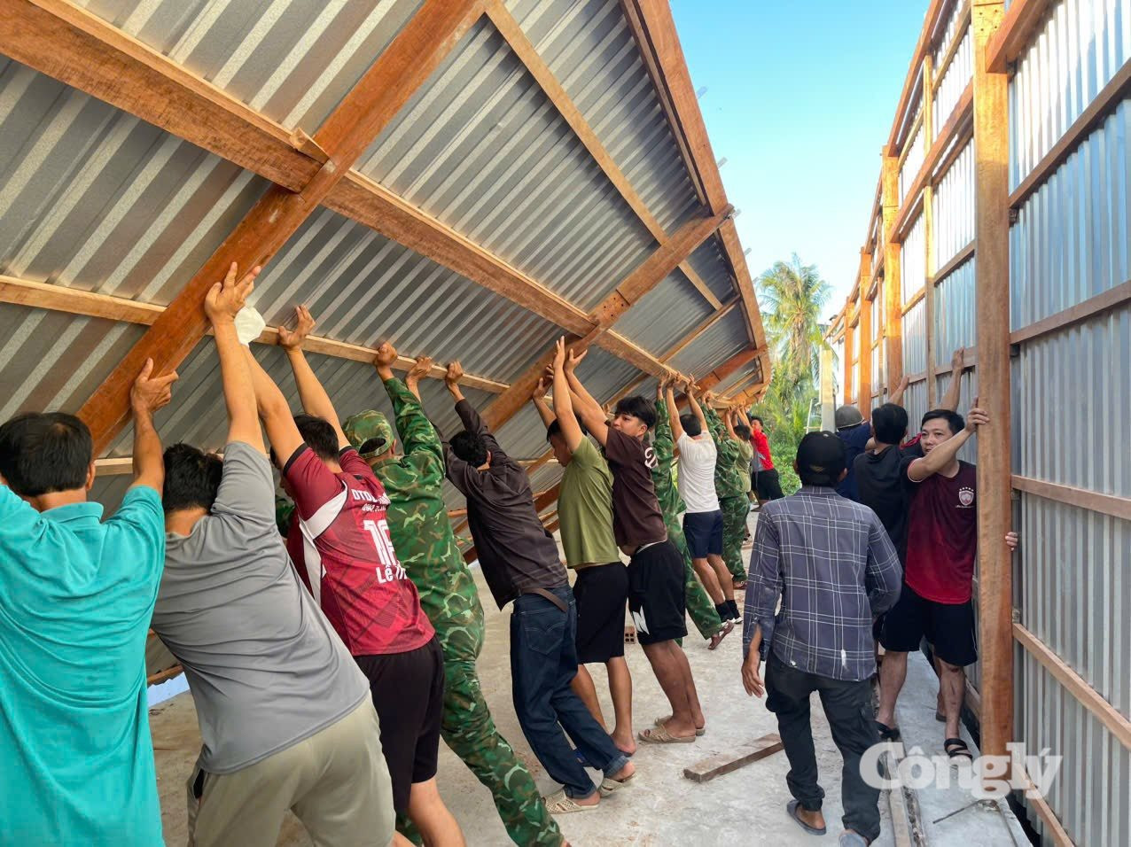 Cán bộ, chiến sĩ Đồn Biên phòng Đất Mũi cùng người dân dựng lại nhà cho người dân ổn định cuộc sống.