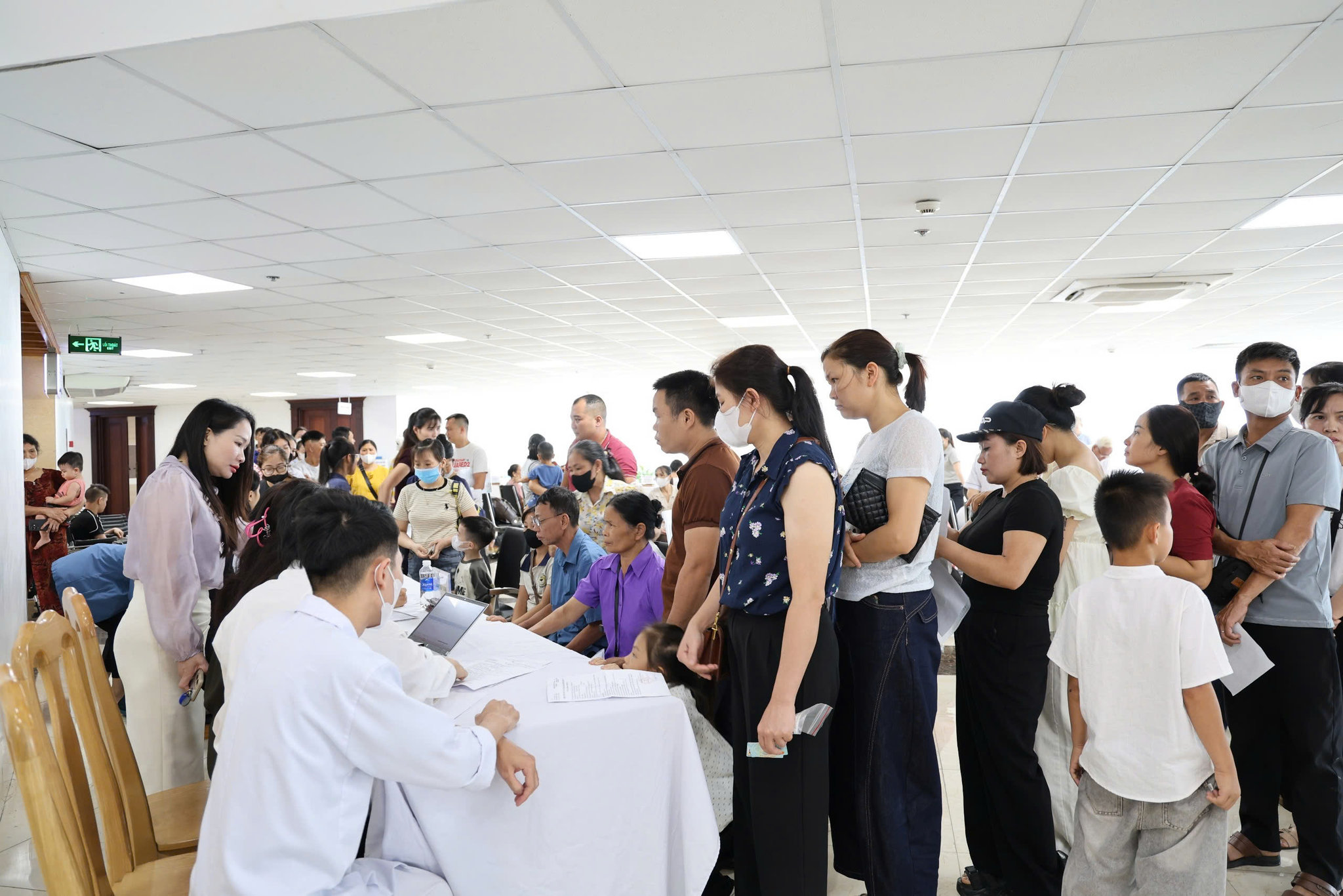 Nhân viên y tế hướng dẫn các gia đình hoàn thiện các thủ tục khám bệnh.
