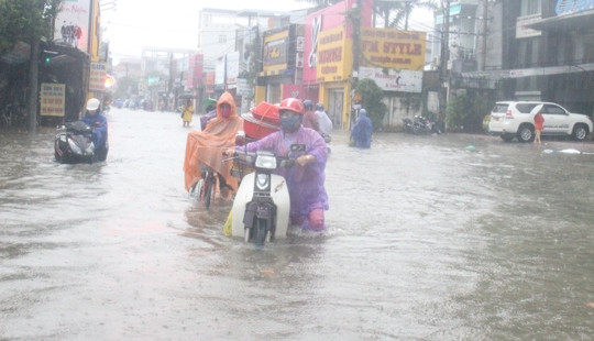 Huế: Mưa lớn kéo dài, người dân bì bõm lội nước trên phố về nhà
