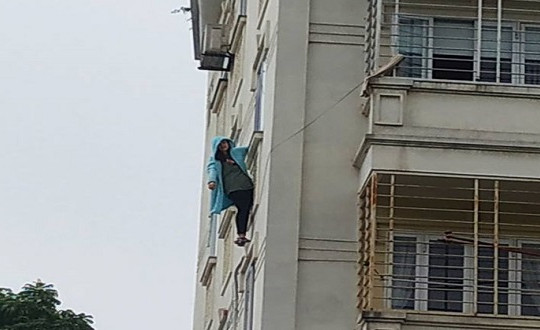 Giải cứu cô gái đu mình trên cửa sổ chung cư ở Hà Nội