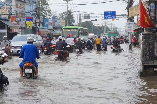 TPHCM: Triều cường dâng cao, người và phương tiện “lội” nước