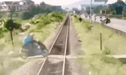 Vượt ngay trước đầu tàu, hai người đi xe máy hú vía thoát nạn trong gang tấc
