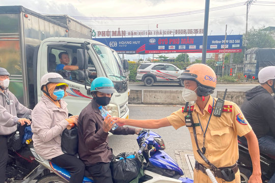 CSGT TP.HCM phát nước suối, tặng nón bảo hiểm cho người dân về quê