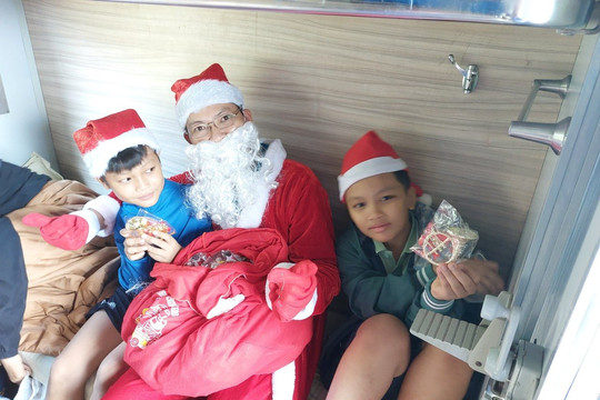 Hành khách đi tàu thích thú vì được ông già Noel phát quà