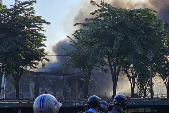 Cảnh sát phong toả một đoạn đường quốc lộ để chữa cháy kho vải