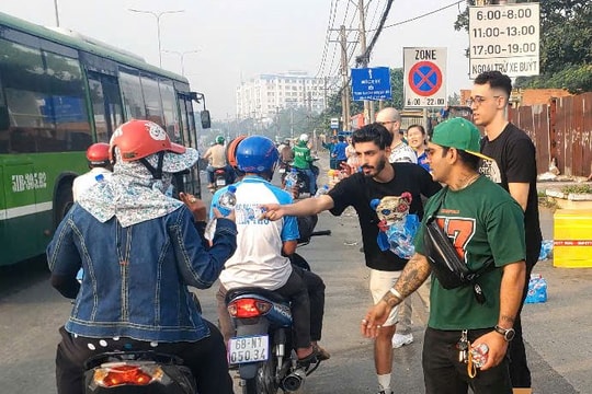 Người nước ngoài tặng nước suối, bánh mì cho bà con về quê ăn Tết