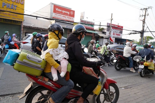 Người lớn với đồ đạc lỉnh kỉnh, trẻ nhỏ ngủ gật trên đường trở lại TP.HCM