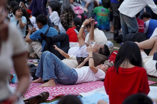 Người lớn trải bạt, trẻ con ngủ vật vã chờ xem diễu binh, diễu hành