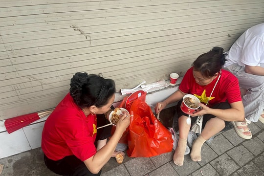 Cận cảnh người xem ngồi ăn trên vỉa hè chờ diễu binh